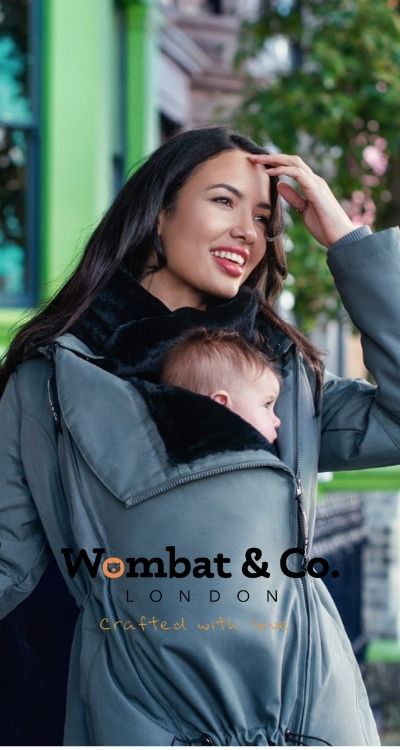 imagen de una mama porteando en invierno con un abrigo de porteo y premama de Wombat &amp; Co London